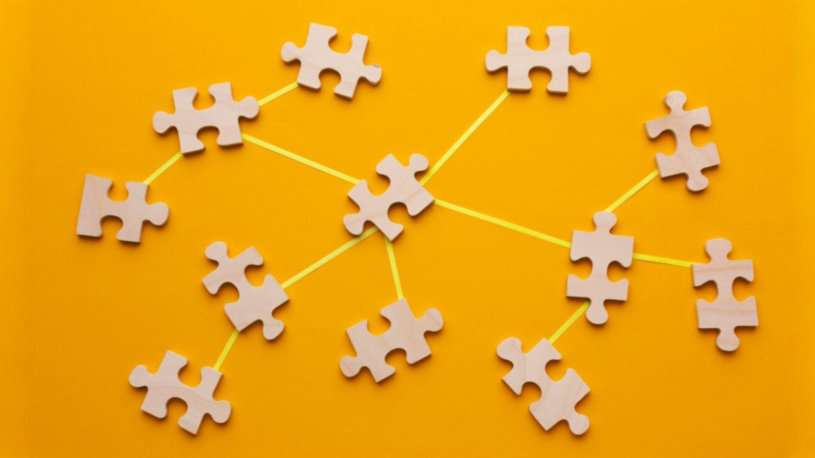Puzzle pieces linked by lines on a bright background, showing how TeamMate's Teams Chat Connector can help messaging tools fit together.